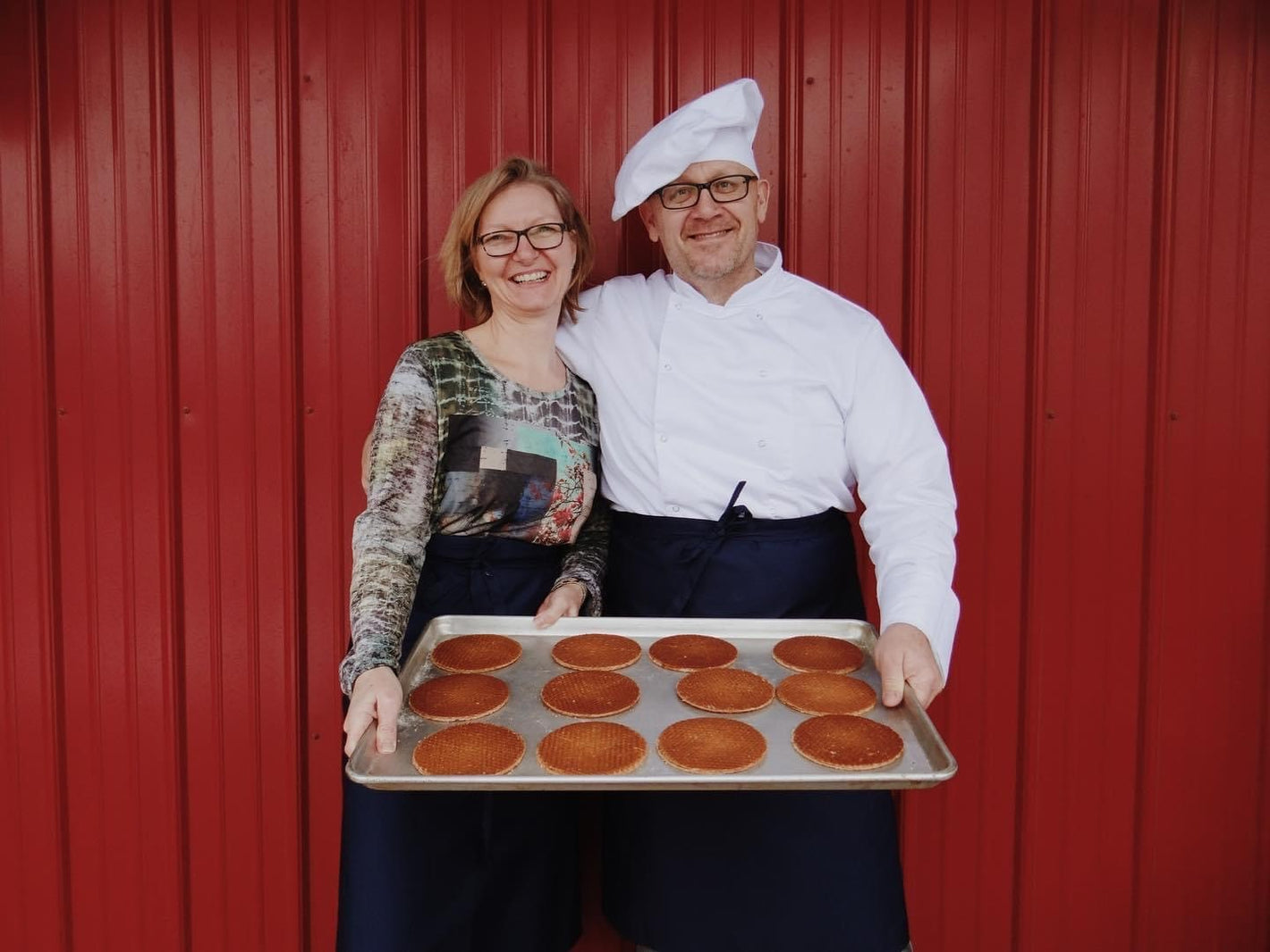 The founders of Dutch Waffle Company, Patrick and Bianca Letens, holding a baking tray with stroopwafels.