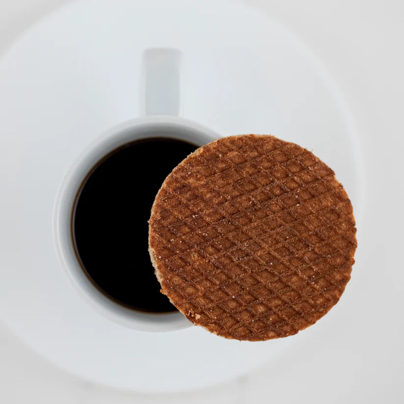 A stroopwafel on top of a cup of coffee